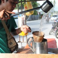 Pouring water over coffee at the side of the street Pouring water over coffee at the side of the street