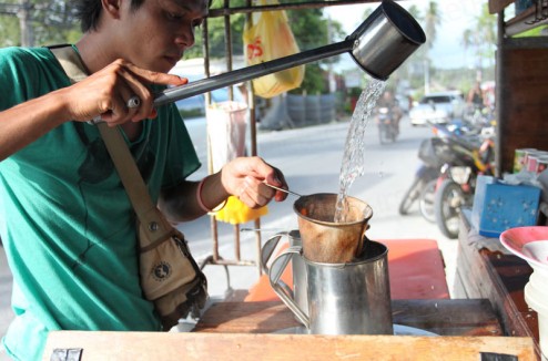 Pouring water over coffee at the side of the street Pouring water over coffee at the side of the street